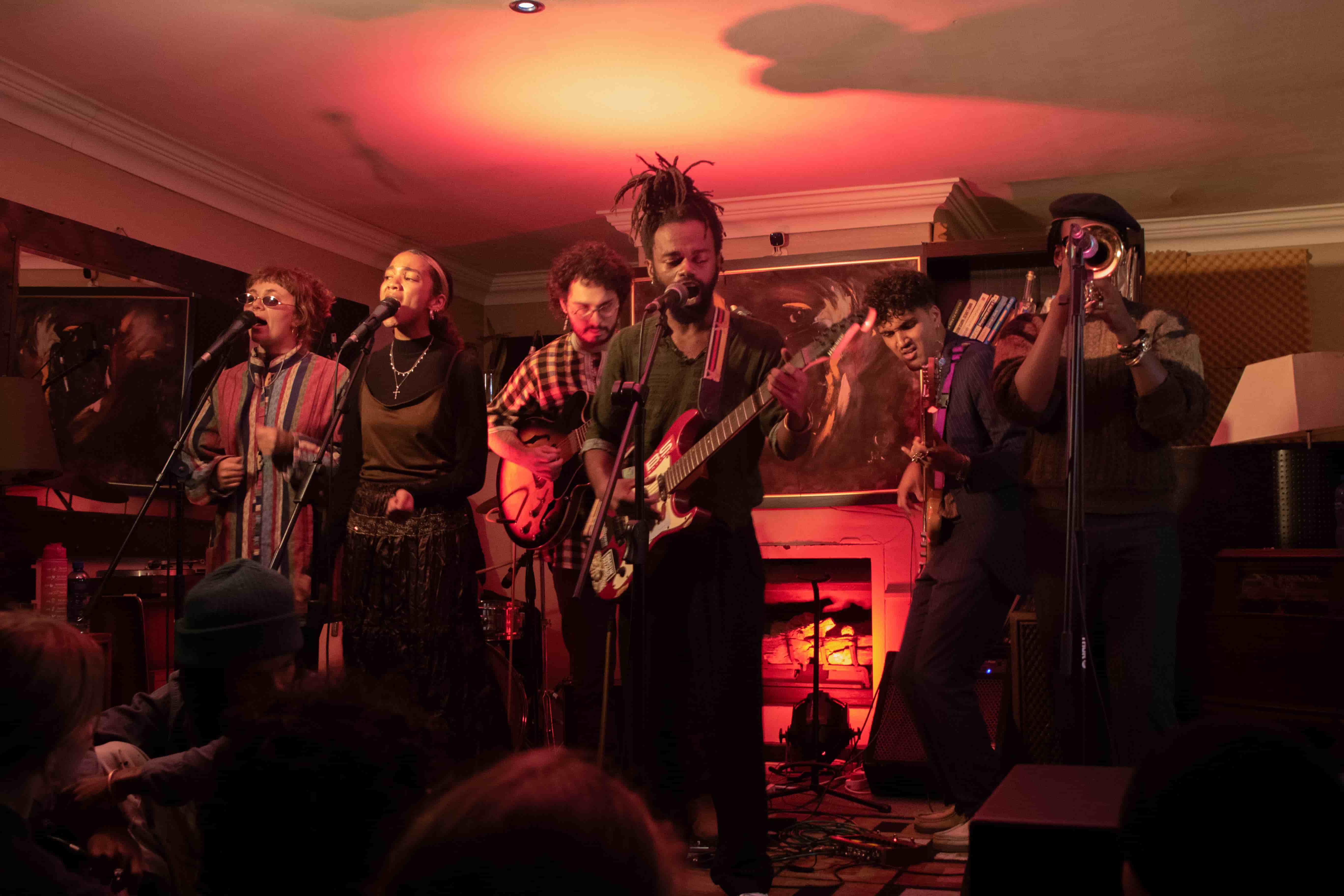 Full band performance in warm red-lit room