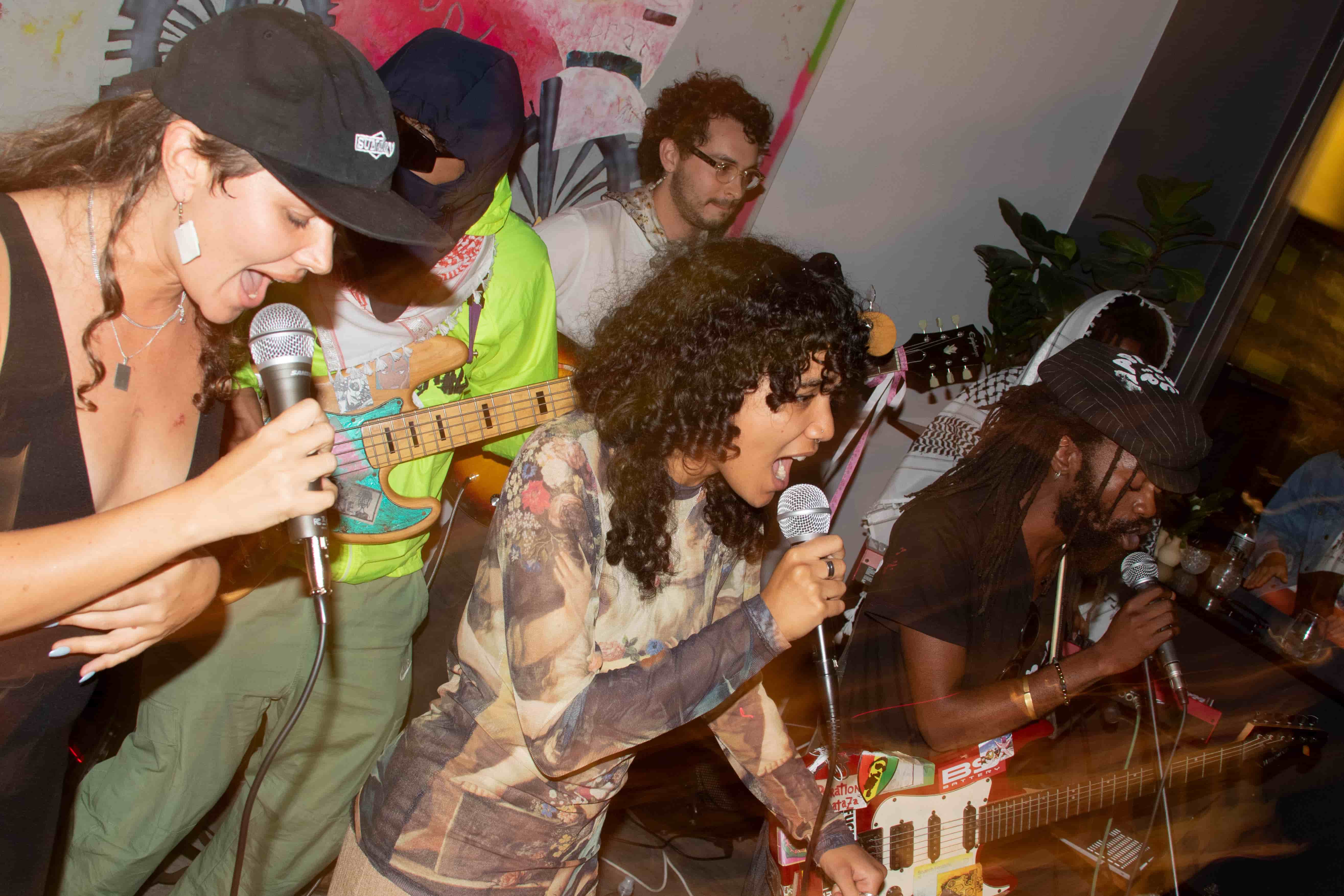 Three vocalists performing intensely on stage
