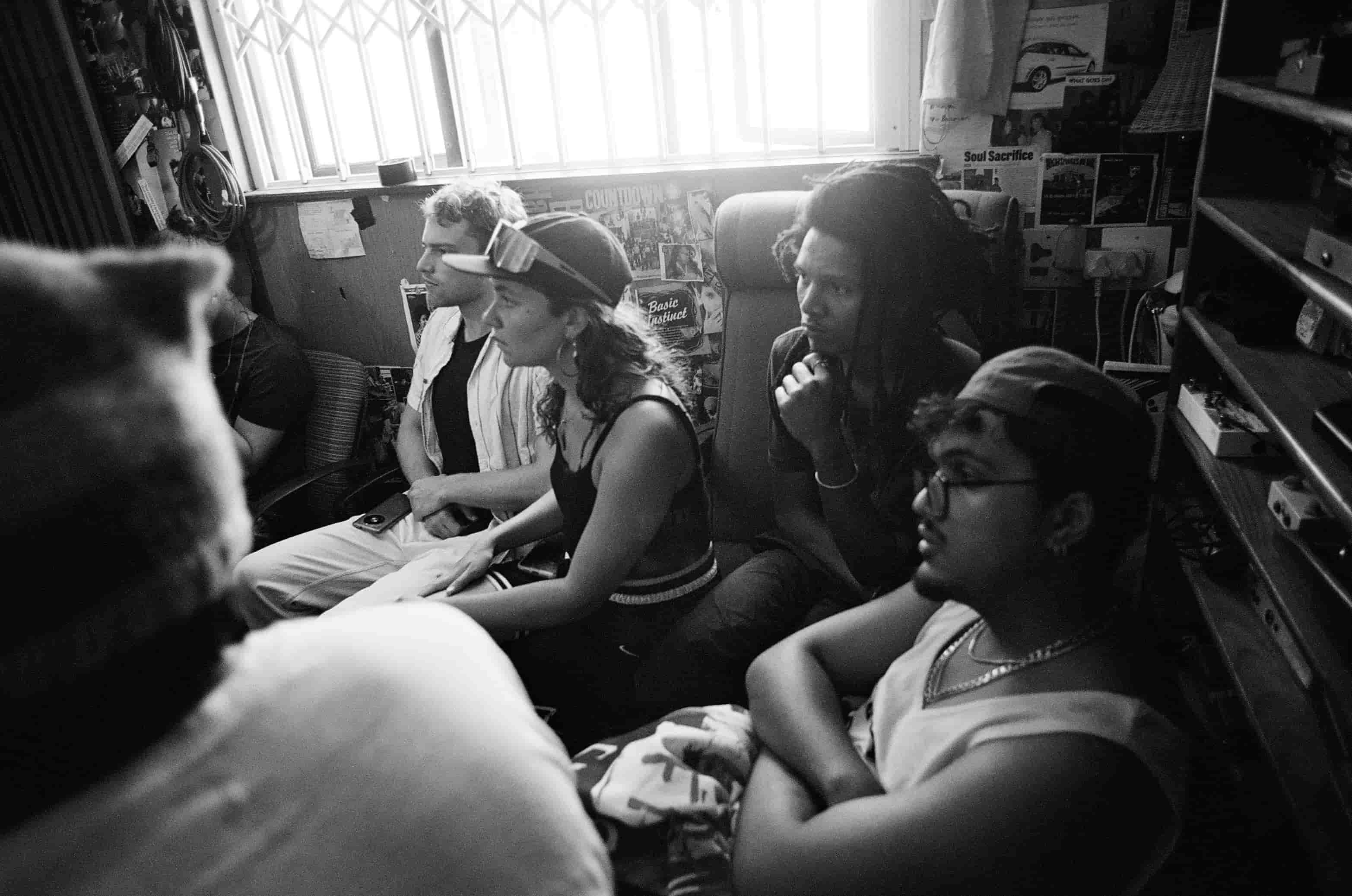 Band members seated backstage, black and white